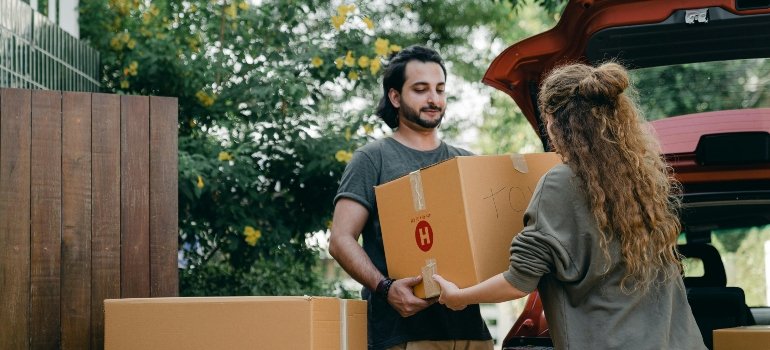 boy and girl carrying a box for temporary storage during LA moves