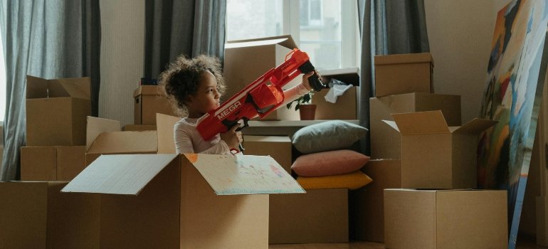a child plays in a cardboard box
