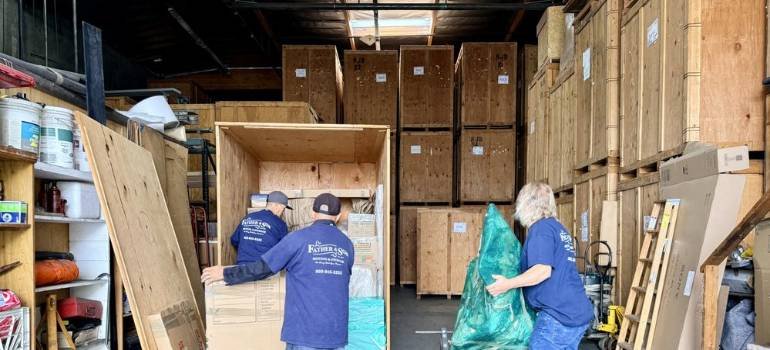 Two men from commercial movers in Los Angeles are carrying the boxes.