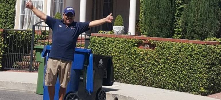 one of the residential movers in front of a new home welcoming his clients