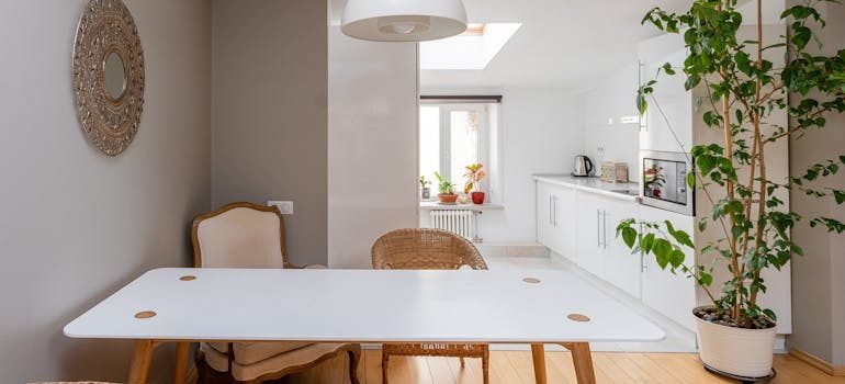 Table and Chair in Room with Kitchen behind