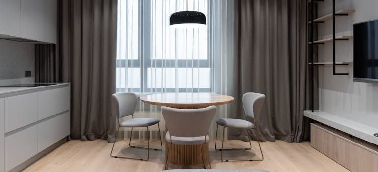 Apartment interior with table and chairs near open kitchen