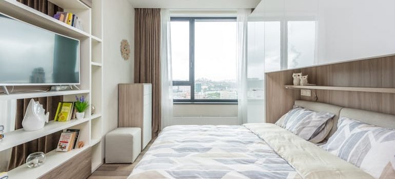 Interior of light bedroom with big window