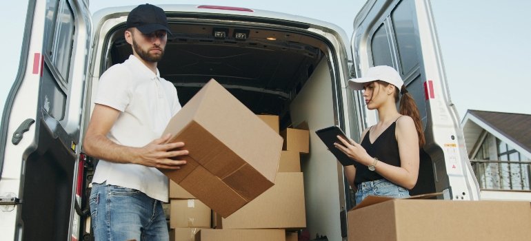 Professional movers carefully loading boxes for a long-distance move from New York to California.