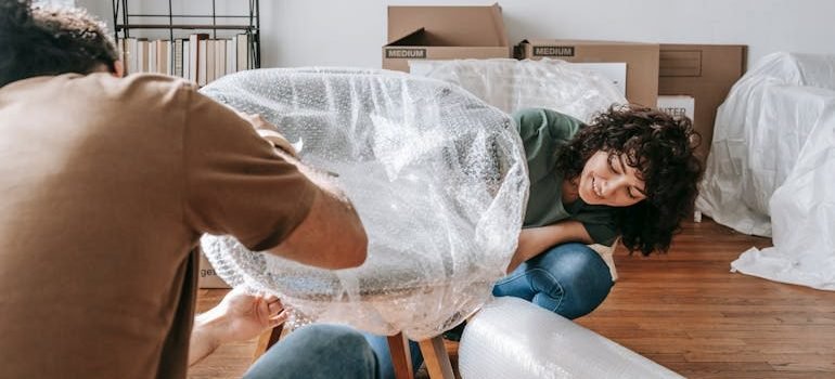 Couple Wrapping A Chair With Plastic