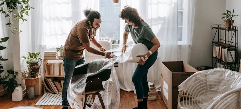 Couple Putting Wrap On Chairs