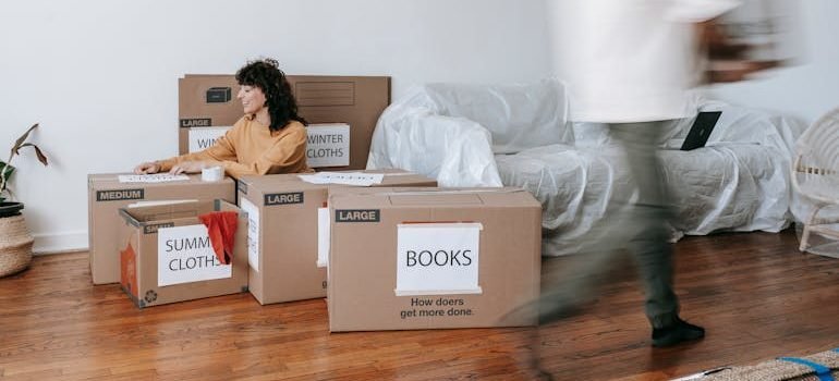 Woman Sitting On Floor Beside Packed Boxes