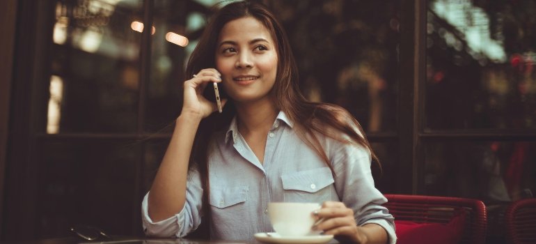 Portrait of Young Woman Using Mobile Phone in Cafe
