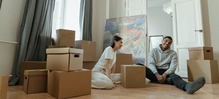 Man in Gray Long Sleeve Shirt Sitting Beside Woman in White Long Sleeve Shirt