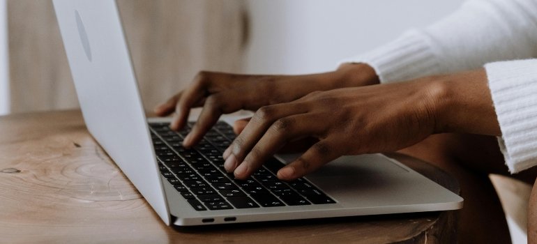 Person researching the California job market on a laptop and securing a job offer before relocating.