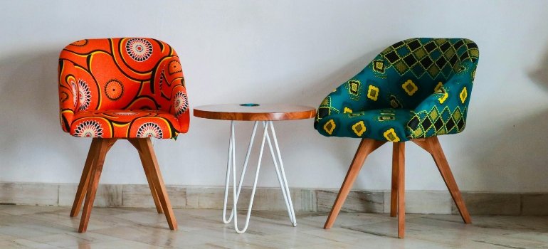 Two assorted-color padded chairs near a side table, safely arranged during a move handled by movers in Northridge.