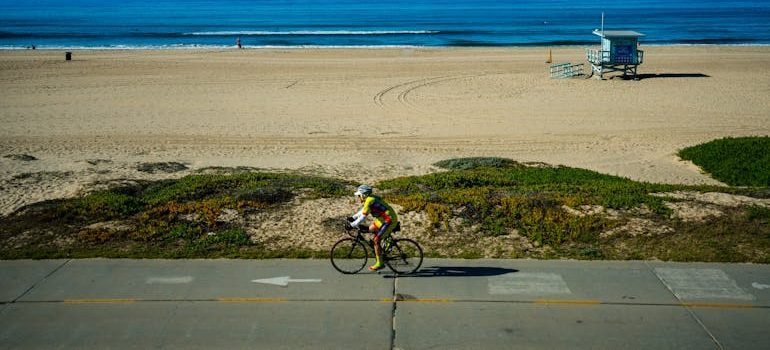 Lonely cyclist riding bike near seashore