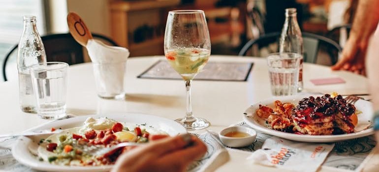 Wine in Clear Glass Near Food on Plate on Table