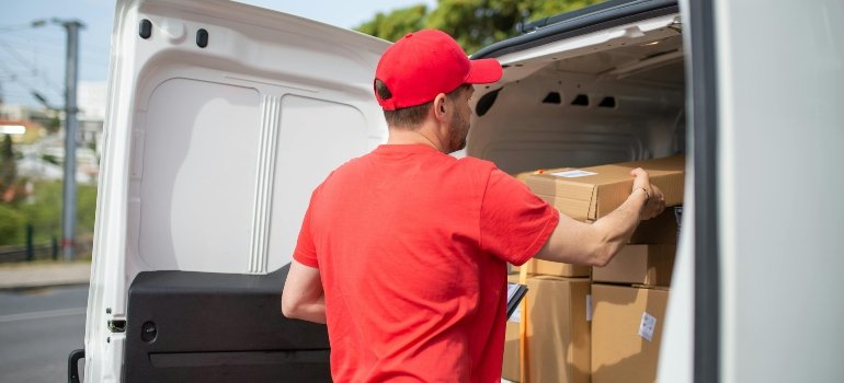 A Man Stacking the Boxes at the Back of a Car