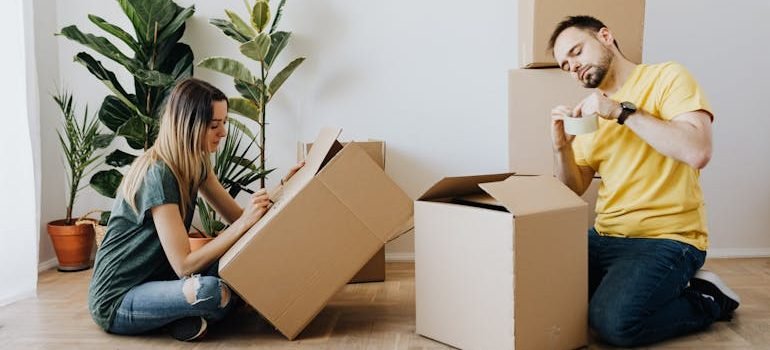 couple packing belongings into carton boxes