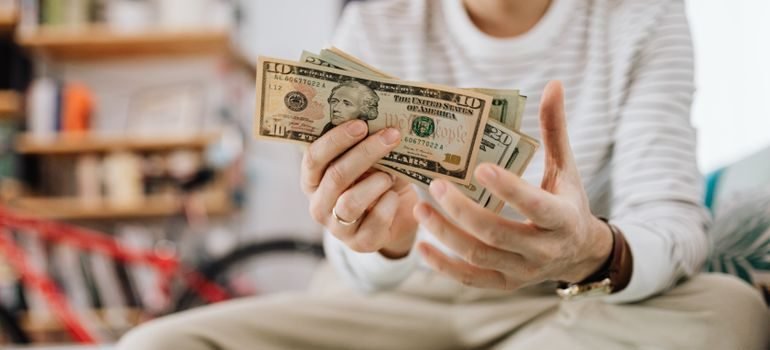 A woman holding and counting money.