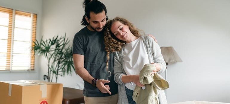couple bonding and unpacking suitcase in new home
