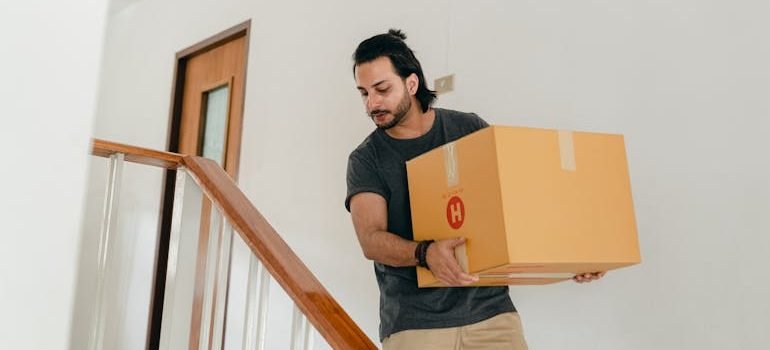 man carrying box down stairs