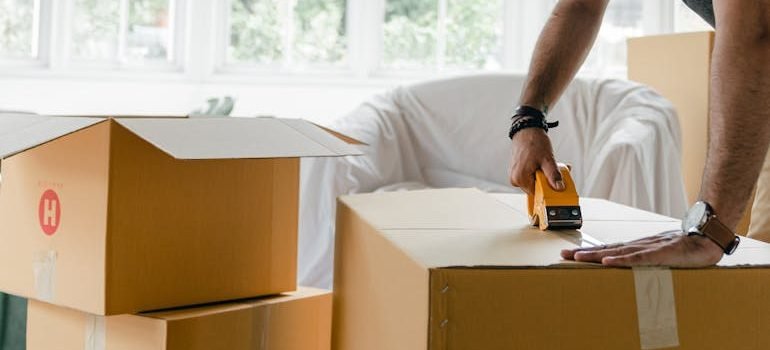 man packing box with duct tape