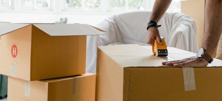 man packing box with duct tape