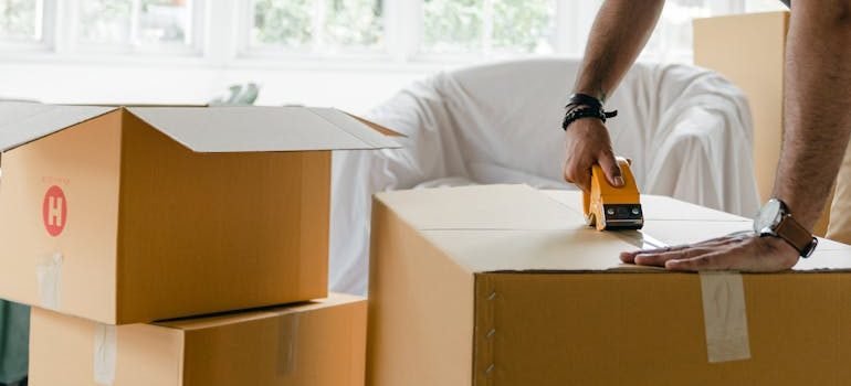 man packing box with duct tape