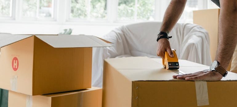 man packing box with duct tape