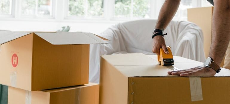 man packing box with duct tape