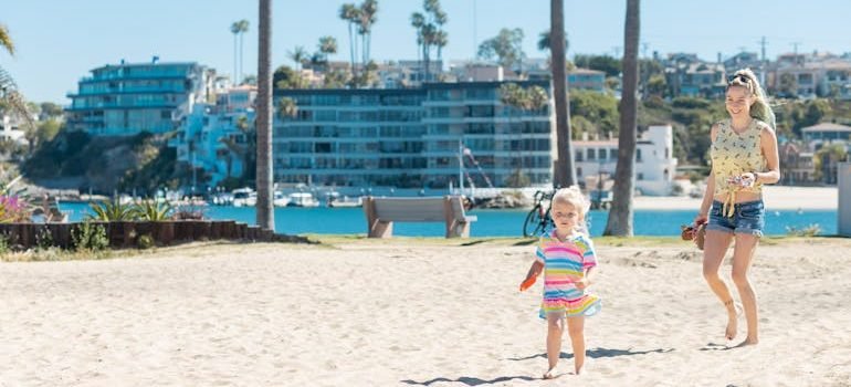 Mother and Daughter Walking on Beach Sand