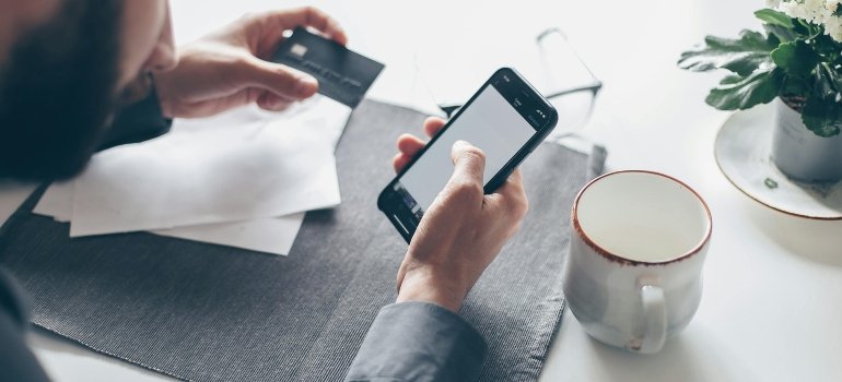 Man Holding a Smartphone and a Credit Card
