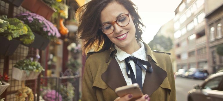 Woman using her smartphone, getting informed about her move, highlighting the convenience of hiring moving companies Thousand Oaks.