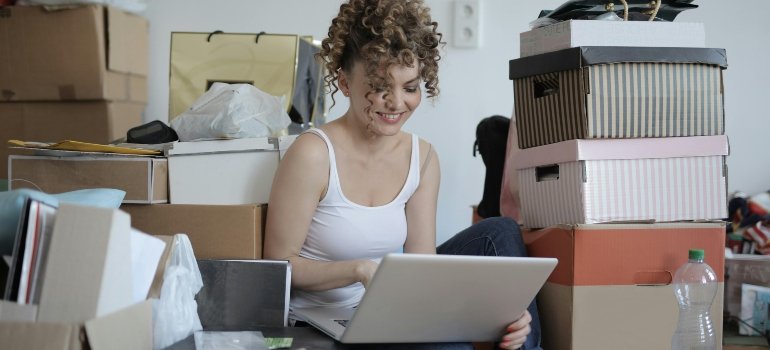Woman using a laptop to compare moving options and prepare to live on your own for the first time.