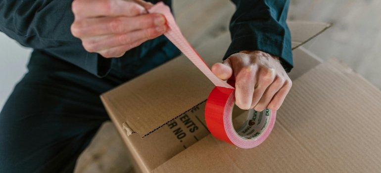 A Person Holding Red Packaging Tape