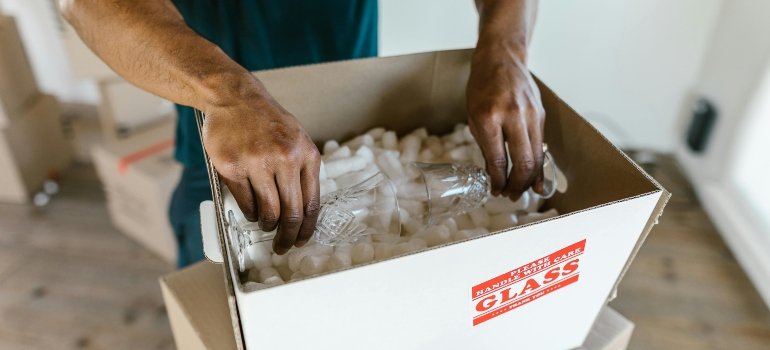 Person Packing Glasses Inside a Package Box