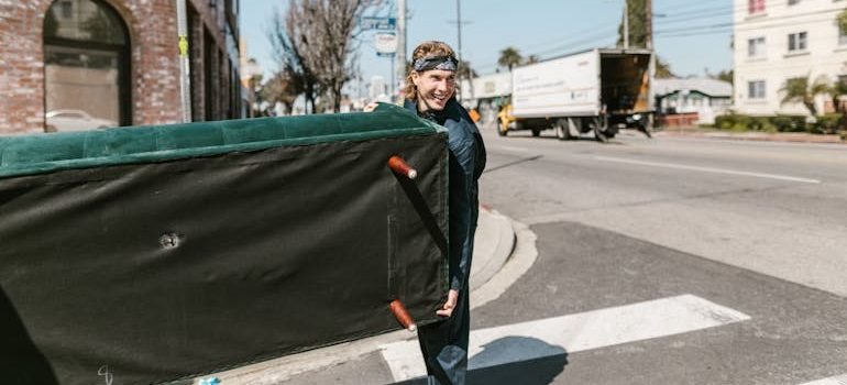 Man in Black Jacket Holding sofa