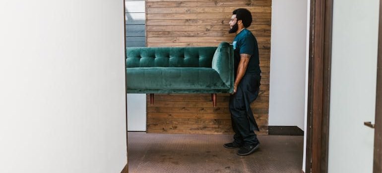 Man in Blue Denim Jeans Sitting on Green Sofa