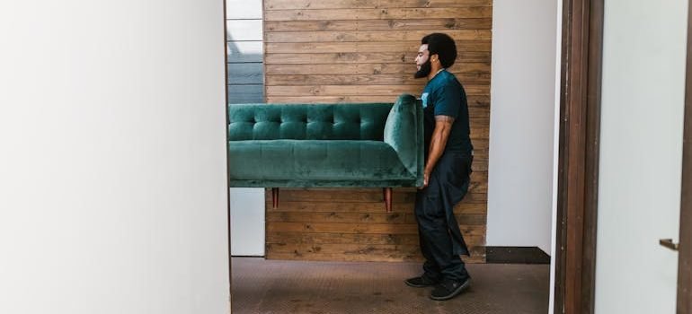 Man in Blue Denim Jeans Sitting on Green Sofa