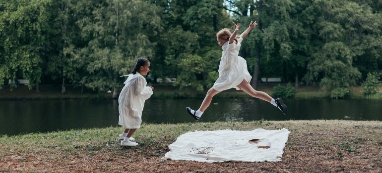 Two Girls in White Dresses Playing in Park
