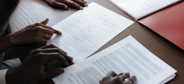 Unrecognizable hand pointing at part of a contract, highlighting tips on how to choose a moving company.
