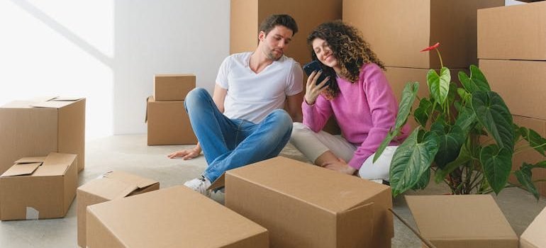 Woman Showing Her Phone to the Man while Sitting on the Floor