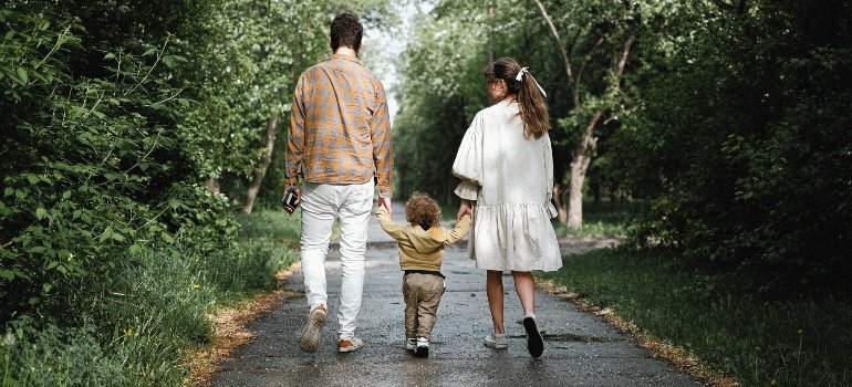 Movers Van Nuys show a couple with their child walking in the park, enjoying family time together.