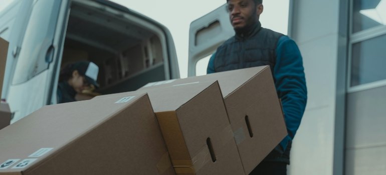 moving crew pushing a Trolley with Carton Boxes