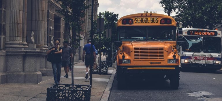 Movers Granada Hills helping families relocate near schools, with a yellow school bus beside a gray concrete building.